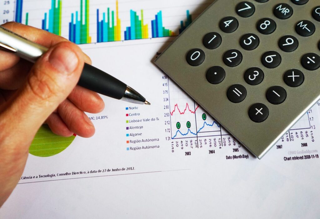 person with calculator and graphs
